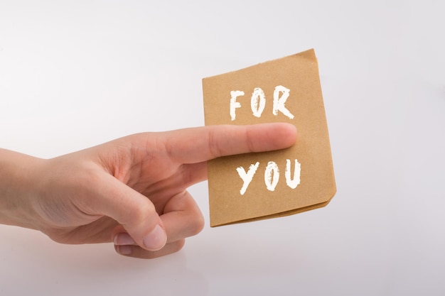 Hand holding paper paper with For you text