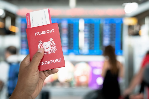 Hand holding passports and borading pass in the international airport