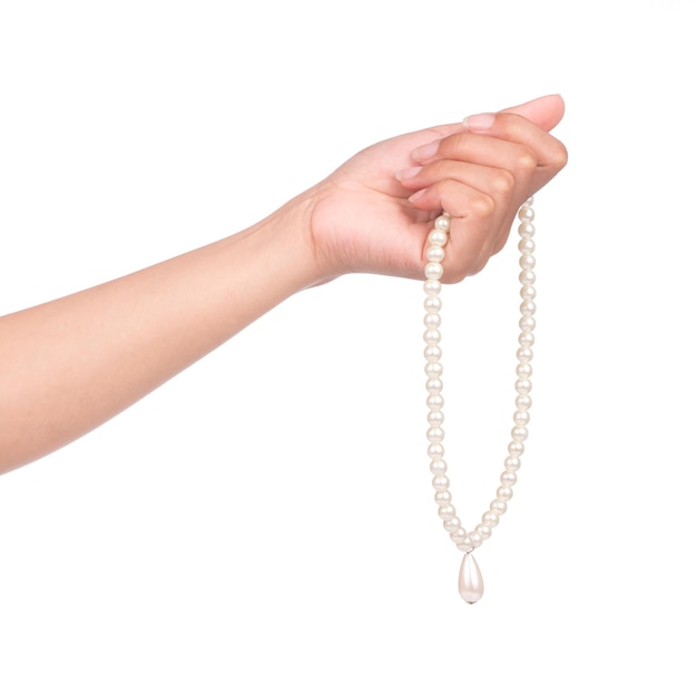 白い背景で隔離の真珠のネックレスを持っている手