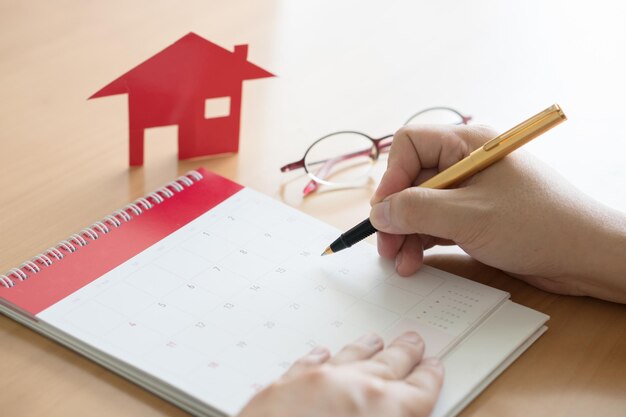 Foto tenendo a mano la penna e il calendario al tavolo