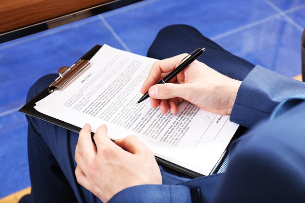 Photo hand holding pen and making notes at conference