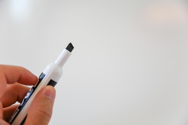 A hand holding a pen with a white background