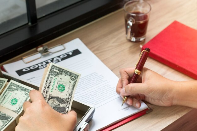 Photo hand holding pen to write business document.