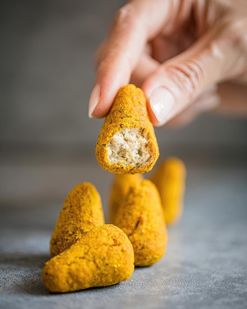 A hand holding a piece of chickpea snack