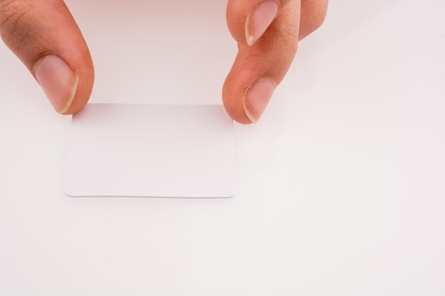 Hand holding a piece of paper on a white background