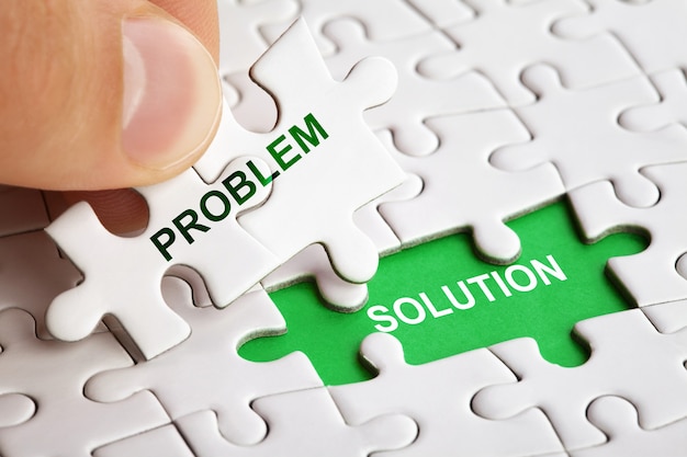 Photo hand holding piece of puzzle with word problem solution. business concept picture