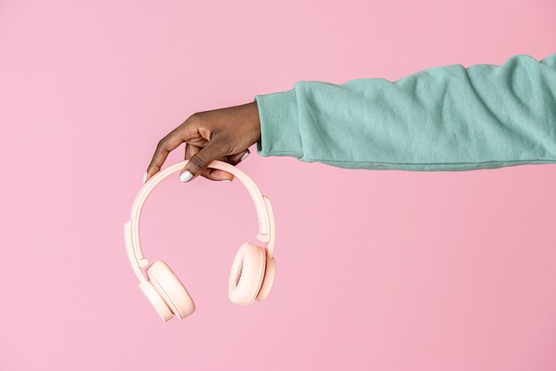 Hand holding a pink headphones