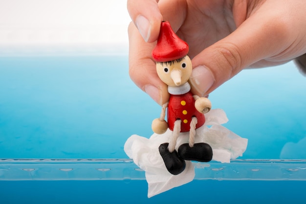 Foto mano che tiene pinocchio in acqua