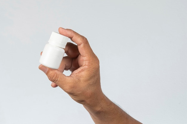 Hand holding plastic medicine box in a gray background