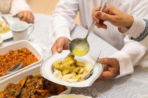 Mano che tiene un piatto di cibo indonesiano speciale. menu tradizionale durante l'eid mubarak in indonesia.