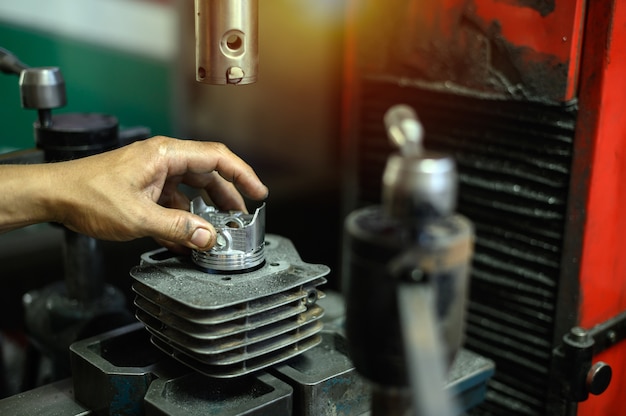 Photo hand holding the plunger on boring machine for motorcycle