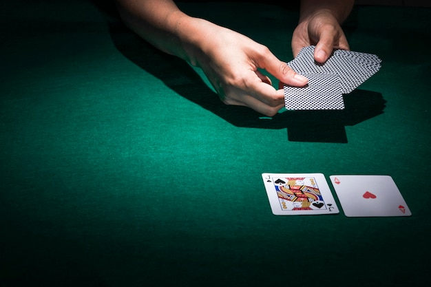 Hand holding poker cards on casino table