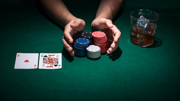 Hand holding poker chips on poker table