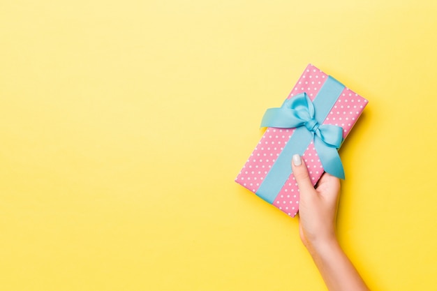 hand holding present with beautiful wrapping paper and ribbon