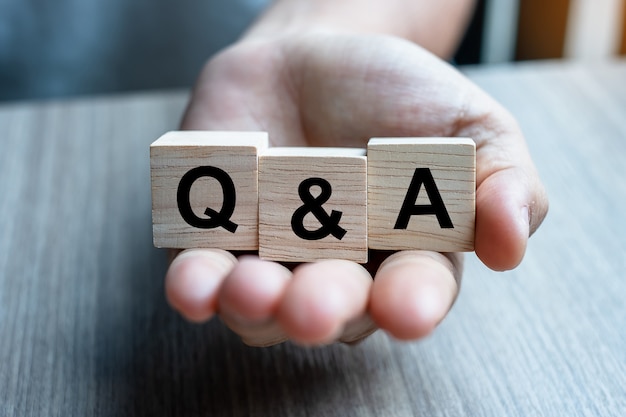 Hand holding Q&A wooden cube block