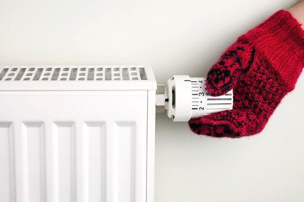 Фото Рука держит термостат радиатора