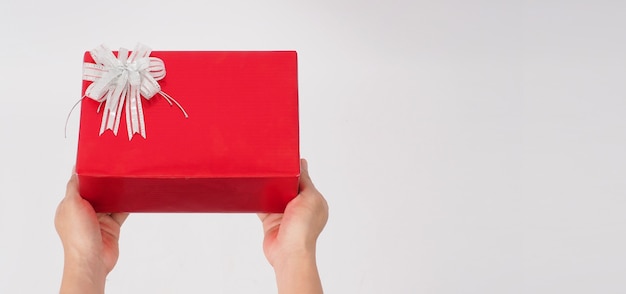 Hand holding red gift box or present and have copy space.For Christmas, New year, birthday concept on white background