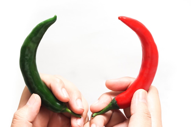 Hand holding red and green hot chili pepper isolated on white background clipping path