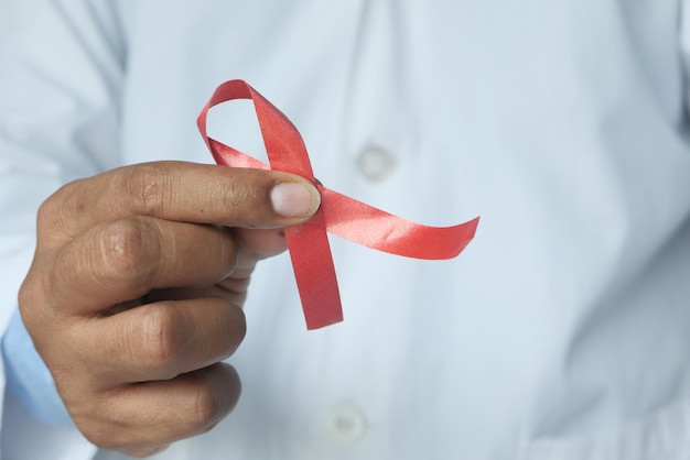 hand holding red HIV ribbon with copy space