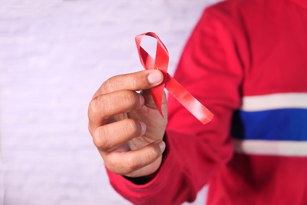 赤いHIVリボンを持っている手