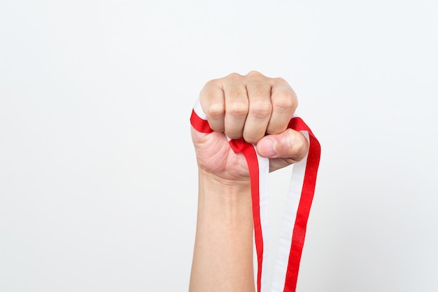 Hand holding red and white Indonesia flag attribute Independence day concept