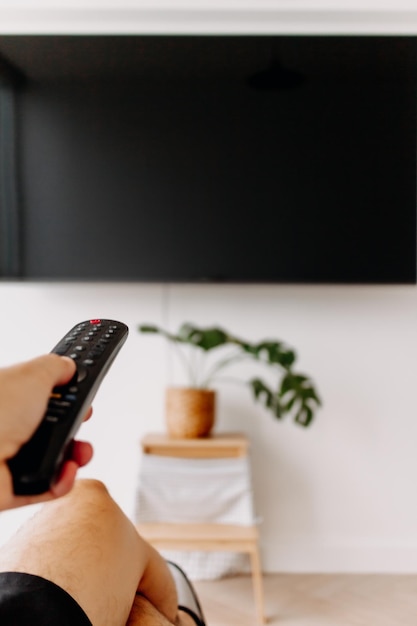 Hand holding remote point at tv concept of watching tv