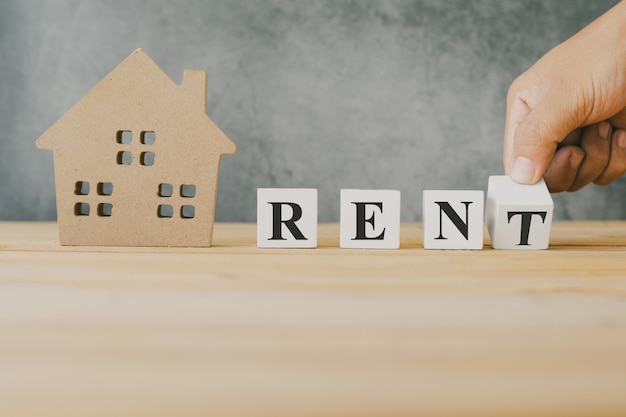 hand holding rent words on wood block