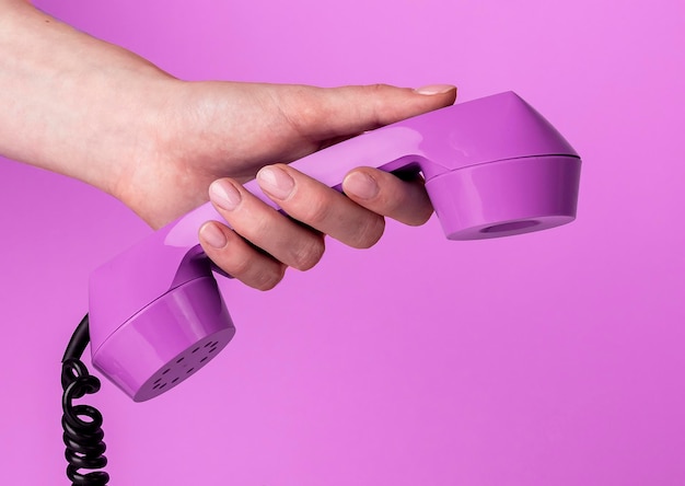 hand holding retro phone receiver on trendy very peri background high quality photo