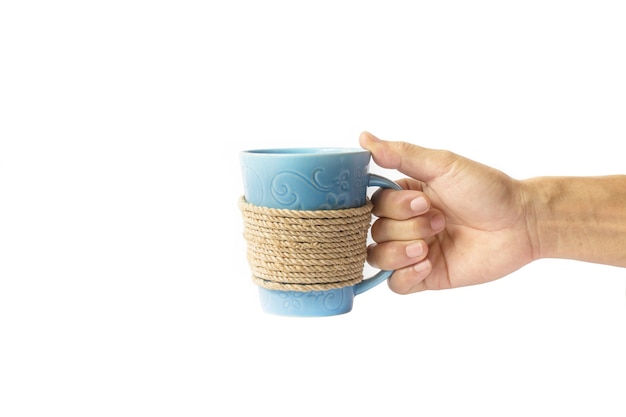 Photo hand holding a rope wrapped coffee mug on white background