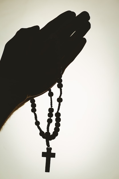 Hand holding rosary beads