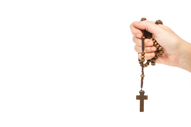 A hand holding a rosary with a cross on it