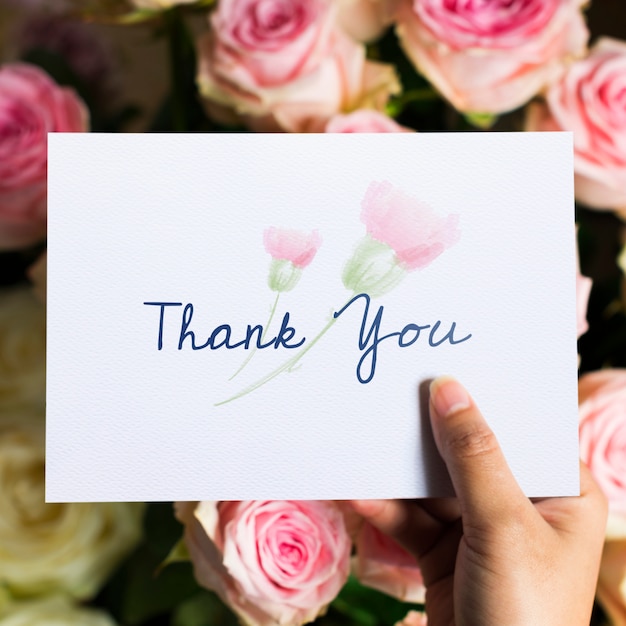 Photo hand holding show thank you card with flowers background