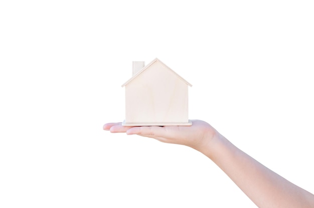 흰색 배경에 고립 된 작은 목조 주택을 보여주는 손을 잡고. 주택 융자와 주택 구입의 개념, 보험.