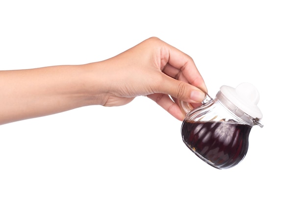 hand holding Small decanter with Soy sauce isolated on the white background