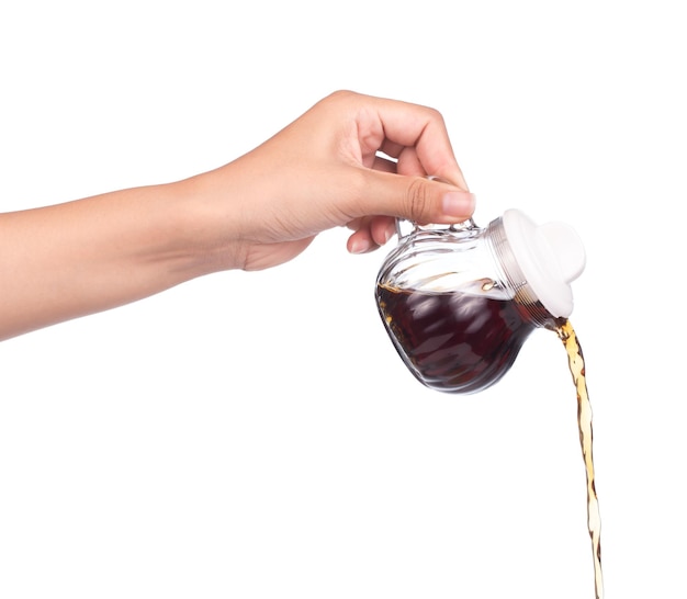 hand holding Small decanter with Soy sauce isolated on the white background