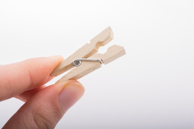 Hand holding a small wooden clothespin