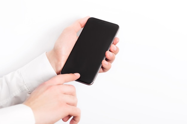 Hand holding smart mobile phone on white and light blurred background