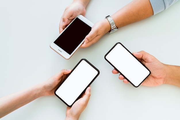 Photo hand holding smartphone mockup of blank screen on table.