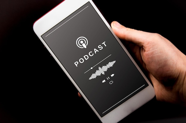 A hand holding a smartphone playing a podcast Concept of listening to podcast