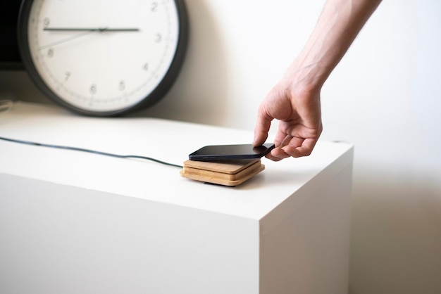 A hand holding a smartphone and put it on the wireless power charger