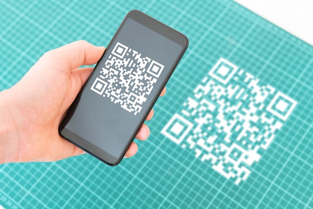 A hand holding a smartphone and scan the qr code to make a payment
