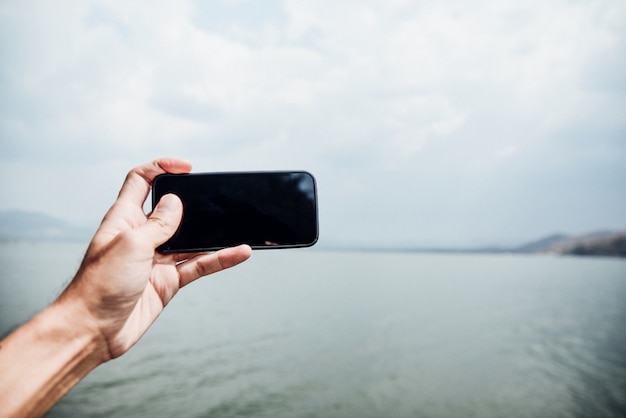 Hand holding smartphone on sky background Technology vintage style