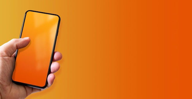 Photo hand holding a smartphone with blank orange screen colorful horizontal banner