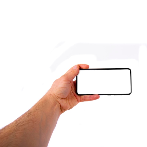 Рука держит смартфон с белым экраном на белом фоне