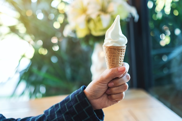 Una mano che tiene il cono di cialda gelato morbido