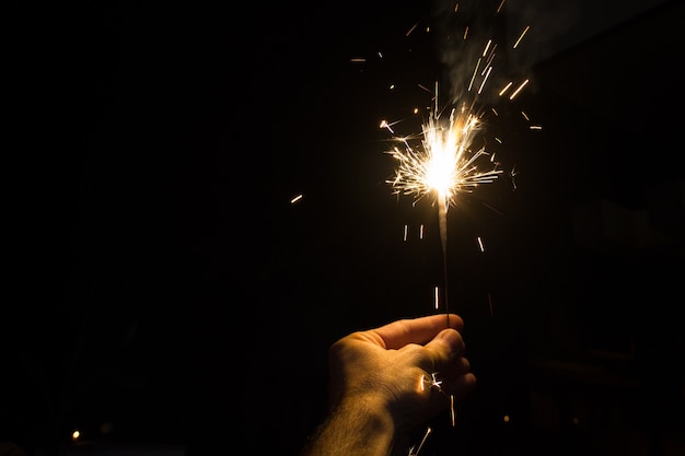 Hand holding a sparkler at night for Diwali Hindu Festival of lights in Mysore, Karnataka, India. Hinduism religion celebration concept