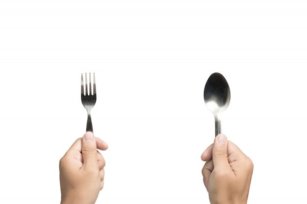 Photo hand holding spoon and fork on isolated background.