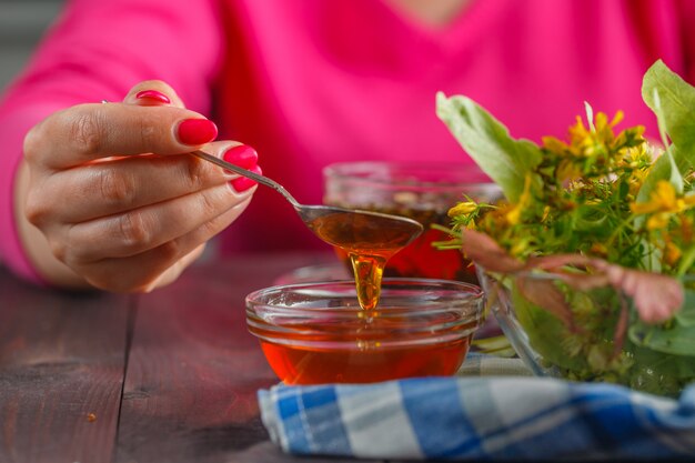 Hand holding spoon with honey