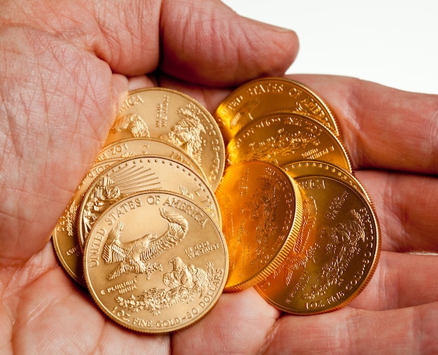 Hand holding stack of gold coins