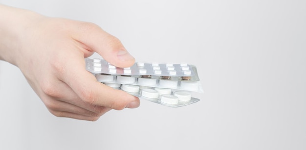 Hand holding a stack of many different pills